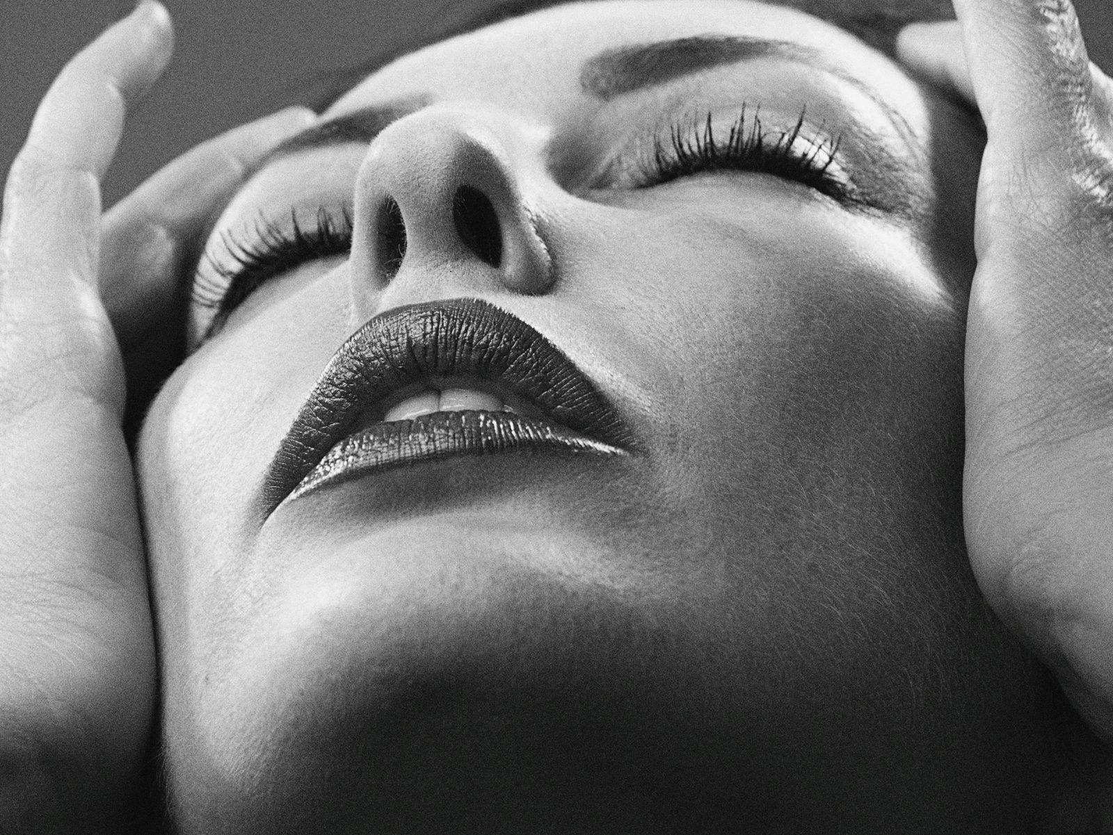 A woman's face in black and white, eyes closed