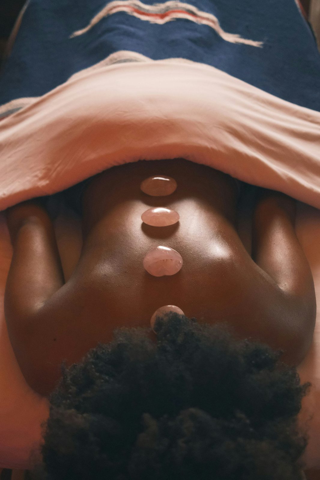 Warm stones lined along a woman's spine
