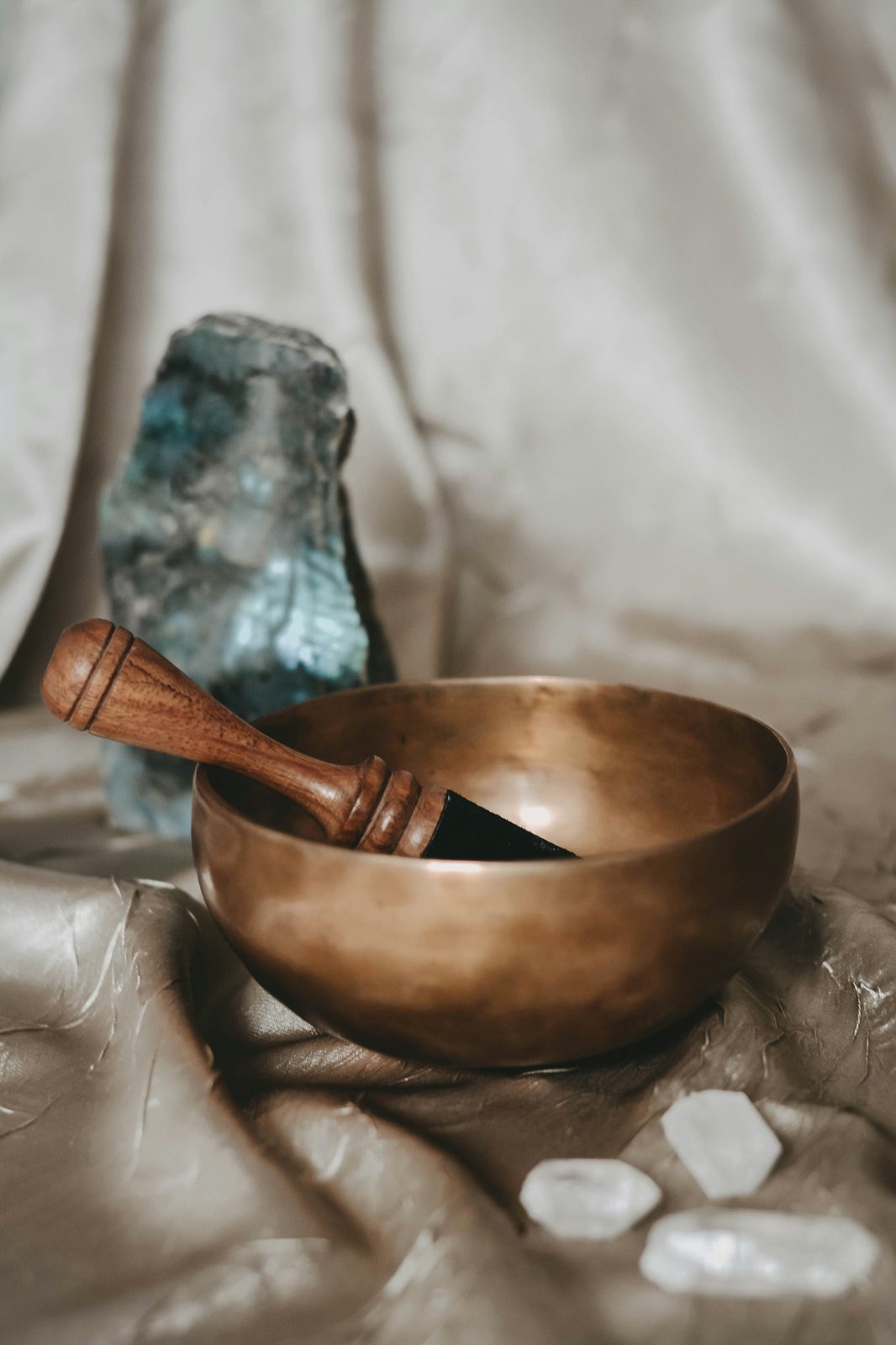 A brass singing bowl resting beside a soft cloth